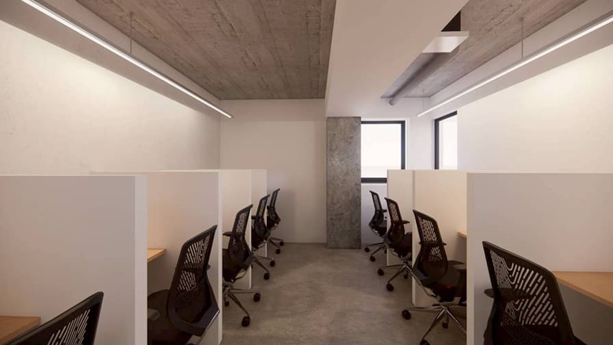 コンクリート打ちっぱなしの天井と白い個室ブースが並ぶ、モダンでインダストリアルな雰囲気のオフィス通路