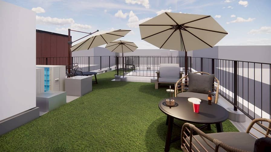 人工芝とパラソル付きのテーブルセットが設置された、開放的な屋上のリラックススペース